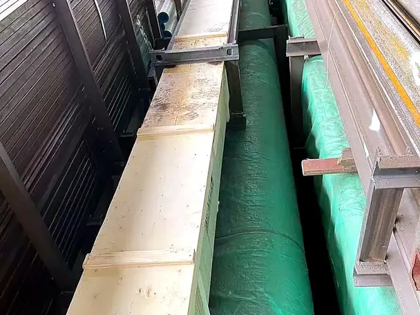 Long steel sections wrapped and strapped to timber bearers